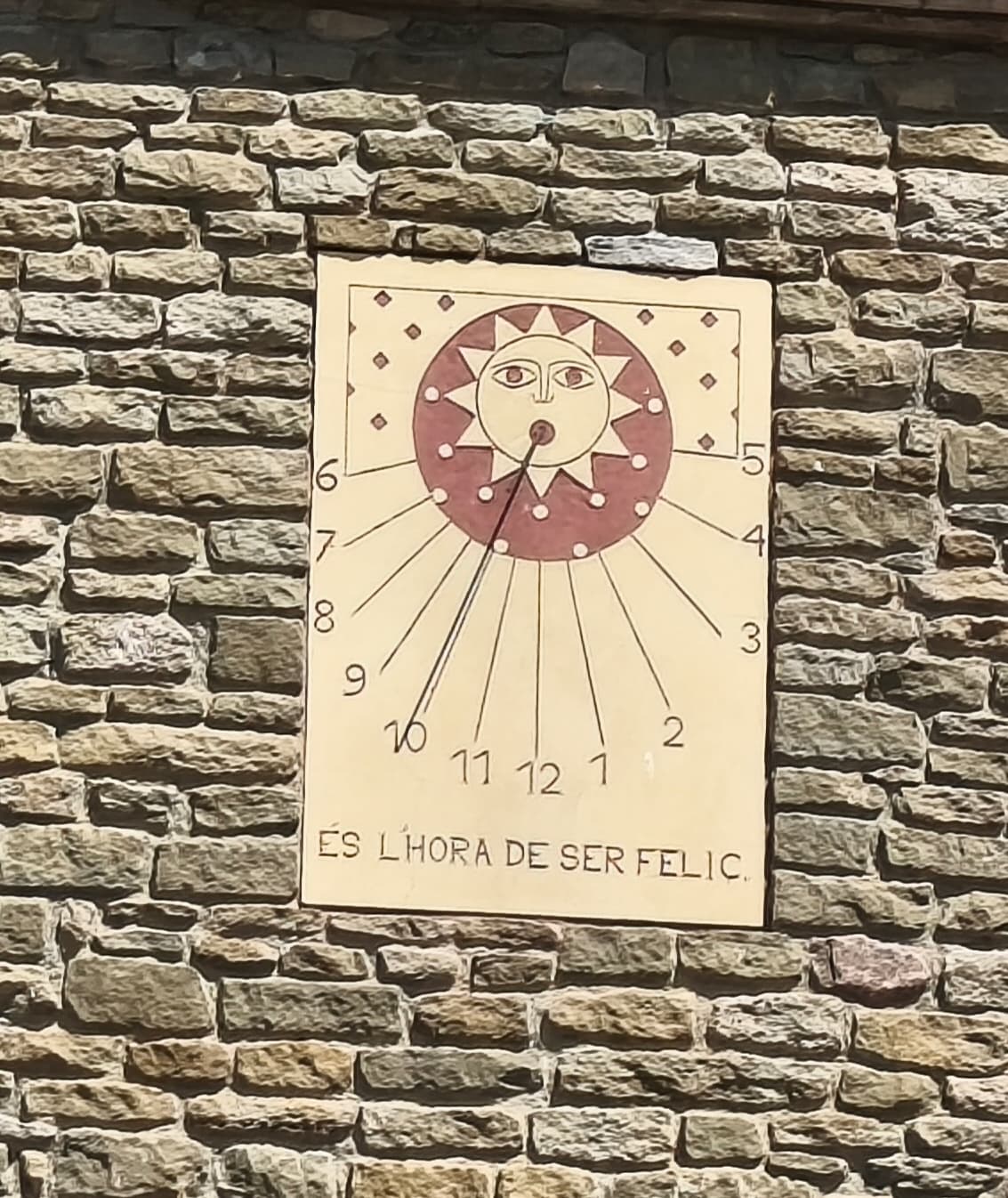 Rellotge de Sol amb el missatge És l'hora de ser feliç
